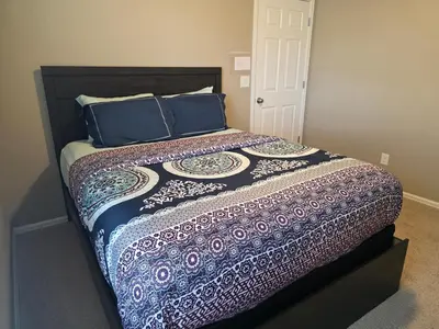 a bedroom with a bed with blue pillows at Humble Home in Aurora