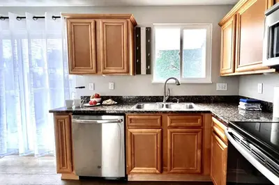a kitchen with wooden cabinets and a sink at Bright Home - Huge Backyard 20 min - Denver & Boulder in Broomfield