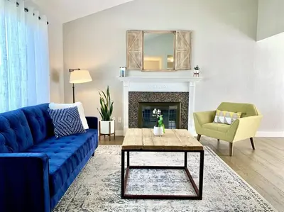 a living room with a blue couch and a fireplace at Bright Home - Huge Backyard 20 min - Denver & Boulder in Broomfield