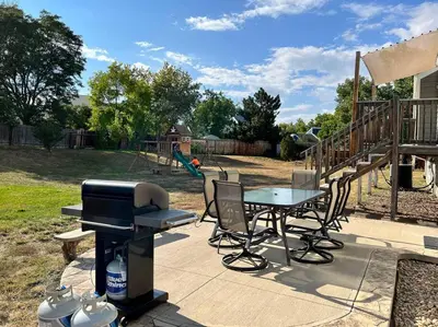 a grill and a table and chairs on a patio at Bright Home - Huge Backyard 20 min - Denver & Boulder in Broomfield