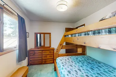 a bedroom with two bunk beds and a mirror at Mallard Retreat in Tabernash