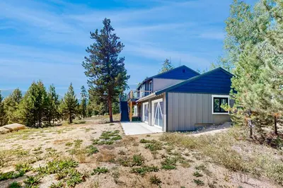 a blue house on a hill with trees at Mallard Retreat in Tabernash