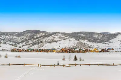 a snow covered town with a mountain in the background at Mallard Retreat in Tabernash