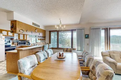 a kitchen and living room with a wooden table and chairs at Mallard Retreat in Tabernash