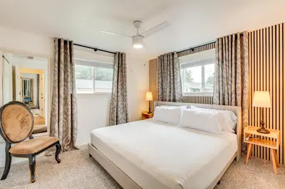 a bedroom with a bed and a chair and windows at Loveland Retreat Near Dtwn with Outdoor Dining! in Loveland