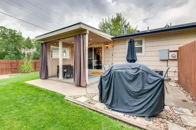 a house with an umbrella in the yard at Loveland Retreat Near Dtwn with Outdoor Dining! in Loveland