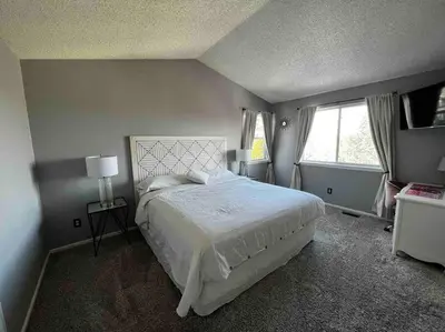 a bedroom with a large white bed and two windows at Charming Broomfield Home Close To Everything! in Broomfield