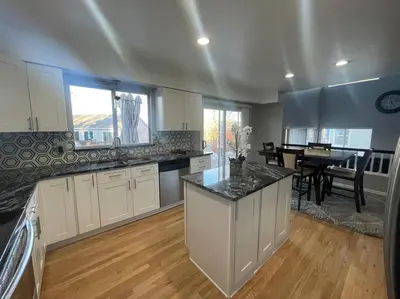 a large kitchen with white cabinets and a dining room at Charming Broomfield Home Close To Everything! in Broomfield