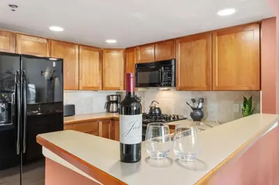 a bottle of wine sitting on a counter with two wine glasses at Lee Martinez Loft Near Poudre Trail and Old Town in Fort Collins