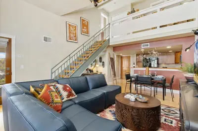 a living room with a blue couch and a table at Lee Martinez Loft Near Poudre Trail and Old Town in Fort Collins