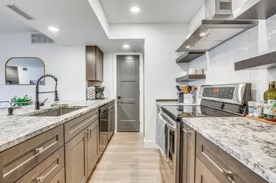 a large kitchen with wooden cabinets and marble counter tops at Patio and Dillon Reservoir Views Chic Frisco Condo! in Frisco