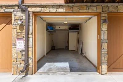 an empty garage with the door open and a sign at Antlers Gulch Retreat townhouse in Keystone