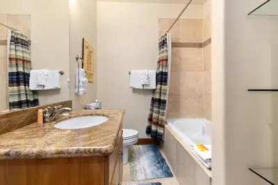 a bathroom with a sink and a toilet and a tub at Antlers Gulch Retreat townhouse in Keystone