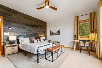 a bedroom with a bed and a wooden wall at Epic Views - Hot Tub - Starlink Internet - Dogs OK in Evergreen