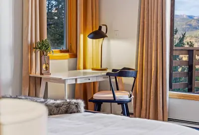 a bedroom with a desk and a chair next to a window at Epic Views - Hot Tub - Starlink Internet - Dogs OK in Evergreen
