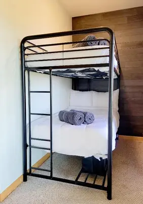 a black bunk bed with white sheets and pillows at Epic Views - Hot Tub - Starlink Internet - Dogs OK in Evergreen