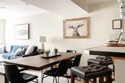 a living room with a table and a blue couch at Alluring Rocky MTN Getaway - Free Parking - Fraser in Fraser