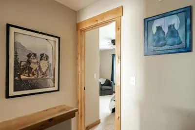 a hallway with a mirror and a picture of dogs at Alluring Rocky MTN Getaway - Free Parking - Fraser in Fraser