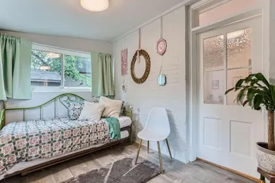 a bedroom with a bed and a chair and a window at Updated Victorian Home in SoBo in Denver