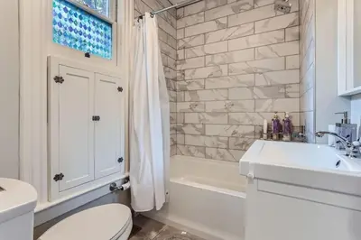 a bathroom with a toilet and a sink and a tub at Updated Victorian Home in SoBo in Denver