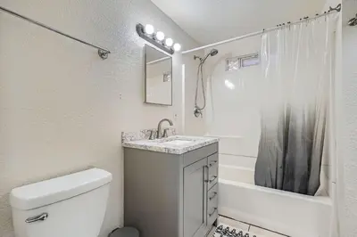 a bathroom with a toilet and a sink and a tub at Vaulted Ceilings, Natural Light Apt near Olde Town in Arvada