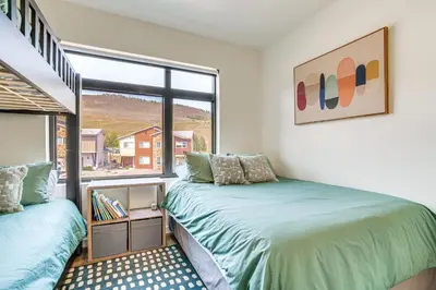 two beds in a room with a window at Mtn-View Slopeside Chalet in Granby Ranch! in Granby
