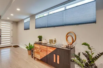 a living room with a large window and a dresser at Hot Tub and Mtn-View Rooftop Deck Golden Home in Golden