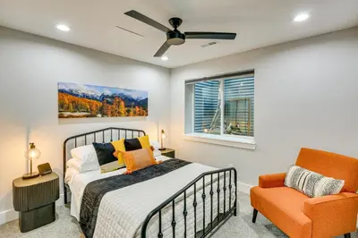 a bedroom with a bed and a chair at Hot Tub and Mtn-View Rooftop Deck Golden Home in Golden
