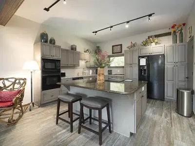 a large kitchen with a large island with bar stools at Luxury By The Lake in Dillon
