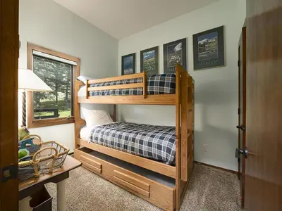 a bedroom with two bunk beds and a desk at Luxury By The Lake in Dillon