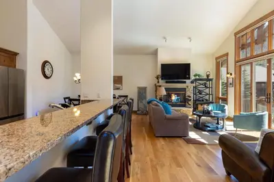 a kitchen and living room with a bar and a fireplace at 43 Thackwell condo in Keystone