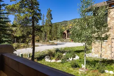 a view of a yard with a house and trees at 43 Thackwell condo in Keystone