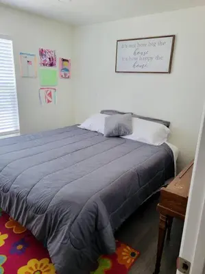 a bed in a bedroom with a sign on the wall at Hot Tub Steam Shower Gym in Charming Family Home! in Lafayette