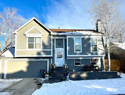 a white house with a garage in the snow at Hot Tub Steam Shower Gym in Charming Family Home! in Lafayette