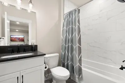 a bathroom with a toilet and a sink and a mirror at Scenic Mountain Retreat Golf, Pickleball, Relax in Loveland