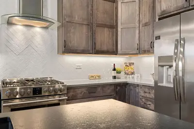 a kitchen with stainless steel appliances and wooden cabinets at Scenic Mountain Retreat Golf, Pickleball, Relax in Loveland