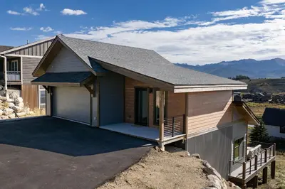 a house with a garage with mountains in the background at Scenic Perch home in Tabernash