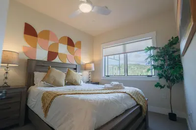 a bedroom with a large bed and a window at WinterPark, Ski, CoffeeBar, Pets and CommunalHotTub in Winter Park