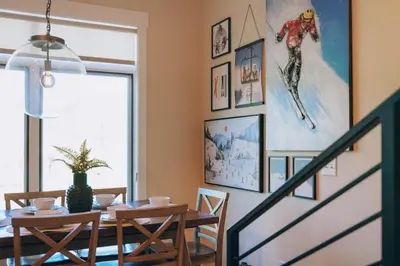 a dining room with a table and a painting on the wall at WinterPark, Ski, CoffeeBar, Pets and CommunalHotTub in Winter Park