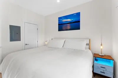 a white bedroom with a bed and a night stand at River West 635 in Silverthorne