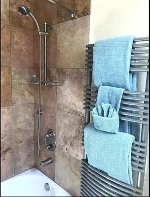 a bathroom with a shower with blue towels and a sink at Energy-Efficient Oasis Cozy Near DT Boulder and trails in Boulder