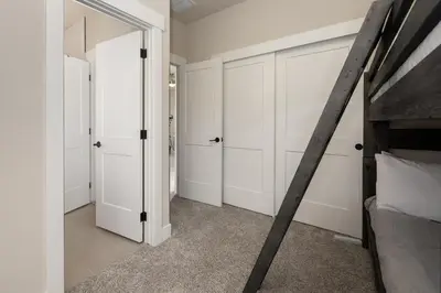 a bedroom with white closet doors and a bed at Wagon Wheel at Rendezvous home in Fraser