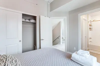 a white bedroom with a bed and a closet at 3 Mi to Dtwn Denver Scenic Townhome with Deck! in Denver