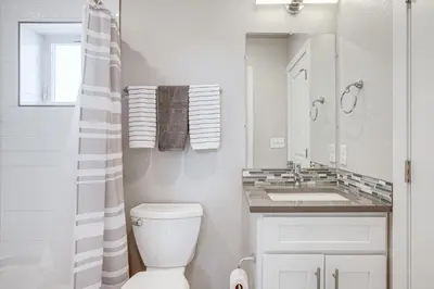 a white bathroom with a toilet and a sink at 3 Mi to Dtwn Denver Scenic Townhome with Deck! in Denver