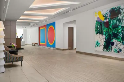 a large room with colorful paintings on the walls at The Art Hotel Denver, Curio Collection by Hilton in Denver