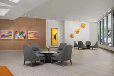 a waiting room with chairs and a table and paintings at The Art Hotel Denver, Curio Collection by Hilton in Denver