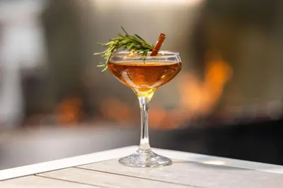 a drink in a glass sitting on a table at The Art Hotel Denver, Curio Collection by Hilton in Denver