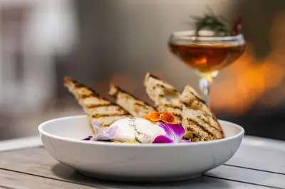 a bowl of bread and a glass of wine at The Art Hotel Denver, Curio Collection by Hilton in Denver