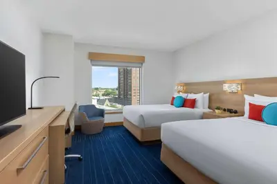 a hotel room with two beds and a flat screen tv at The Art Hotel Denver, Curio Collection by Hilton in Denver