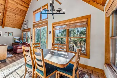 a dining room with a table and chairs and windows at Bright Keystone Getaway w Loft Near Ski Lifts in Keystone